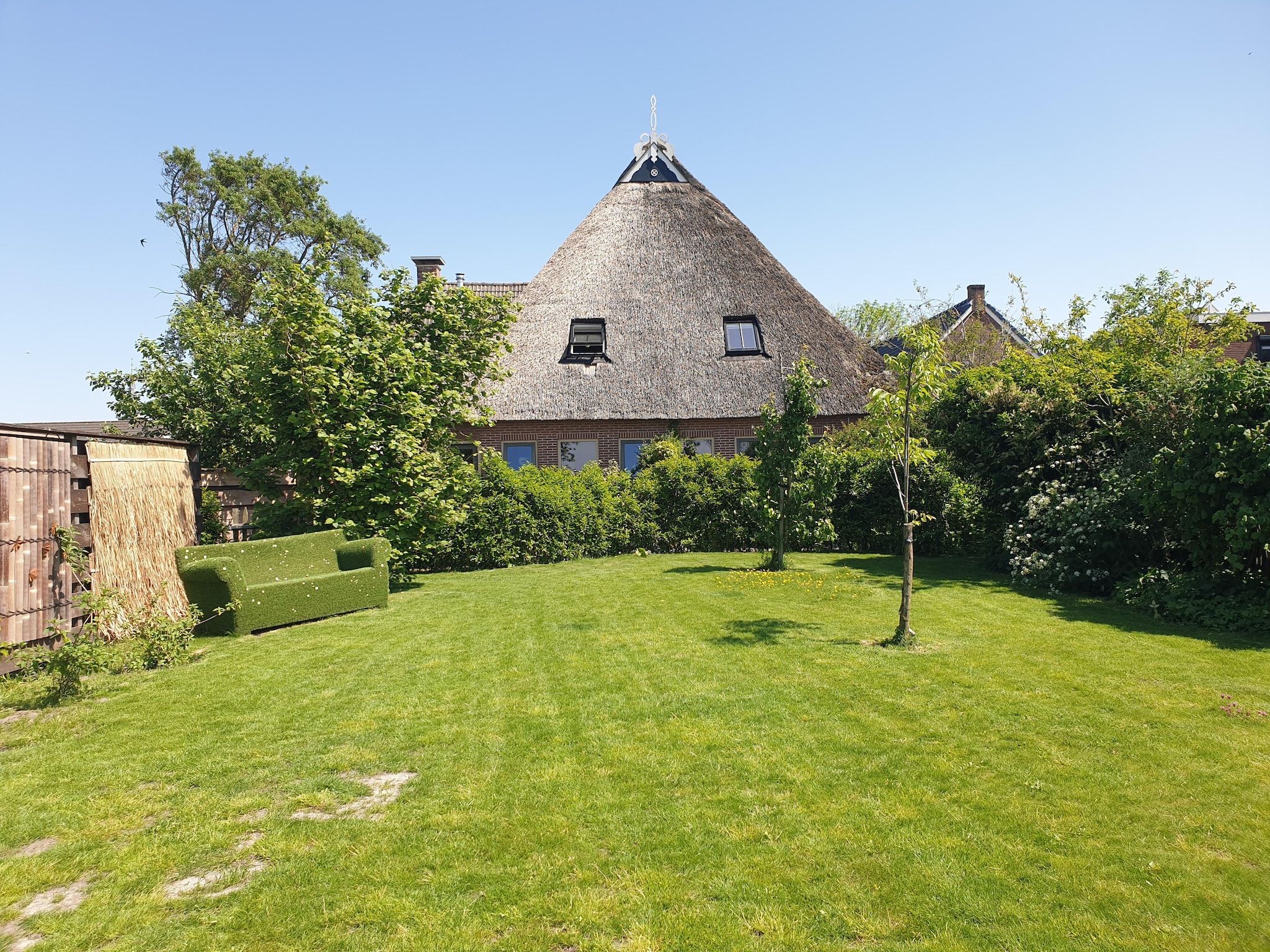 De tuin van 13-17 pax holiday home with separated apartments and gardens in Ternaard