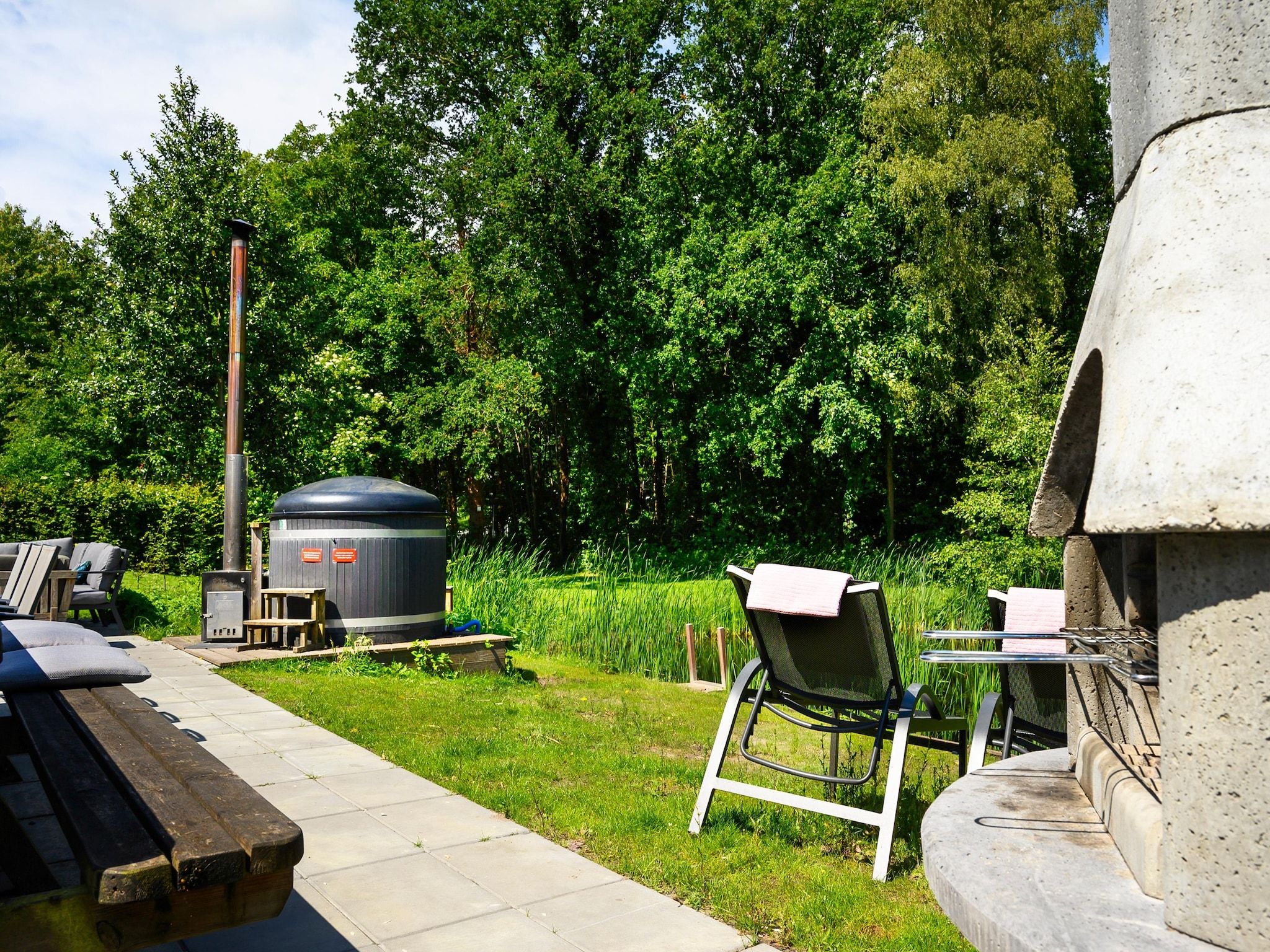 De tuin van 18 pers Ellersinghuis wellness met houtgestookte hottub in Vlagtwedde