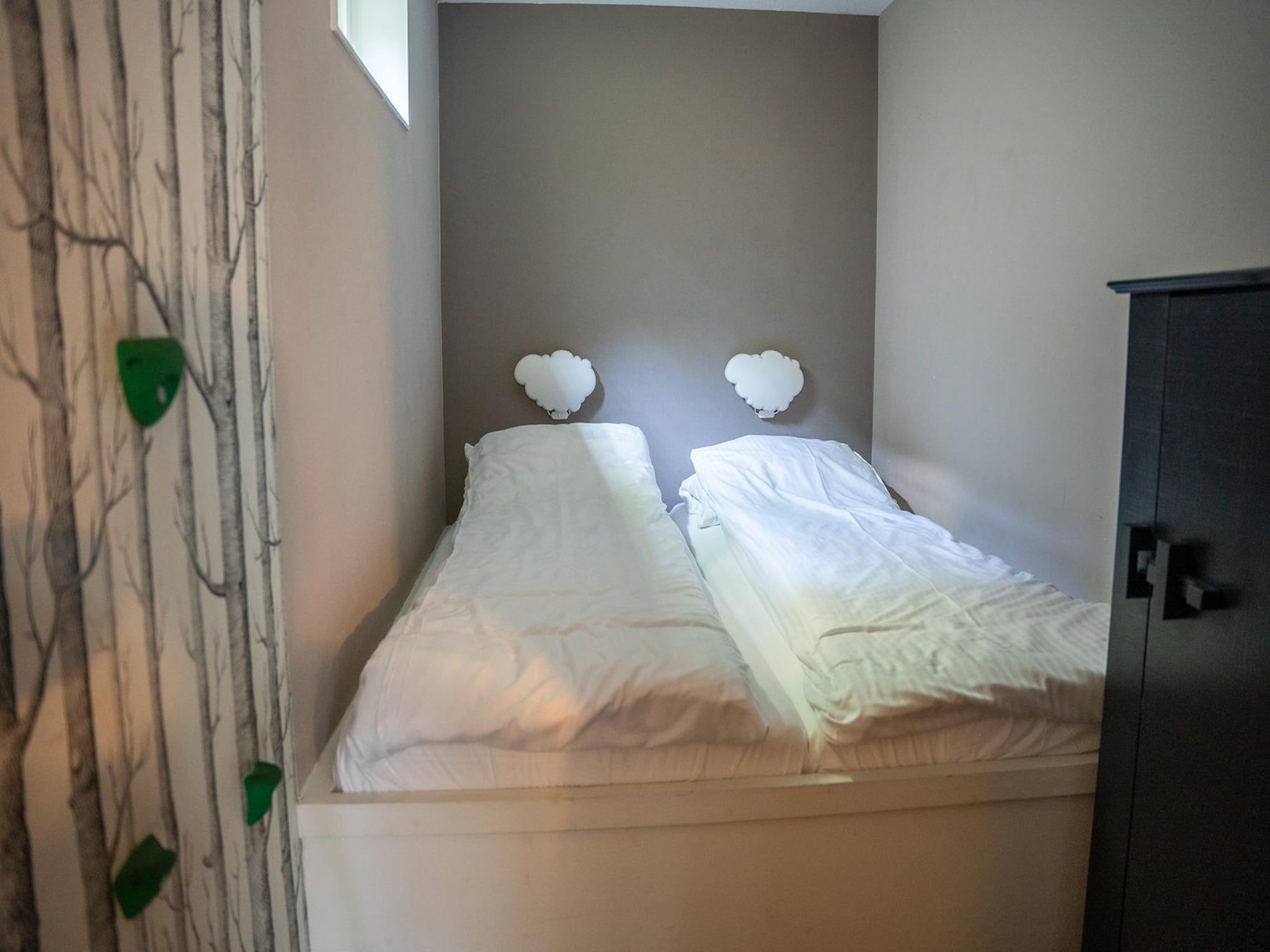 Een slaapkamer van Vlindervallei Boshuis 16p in Ermelo