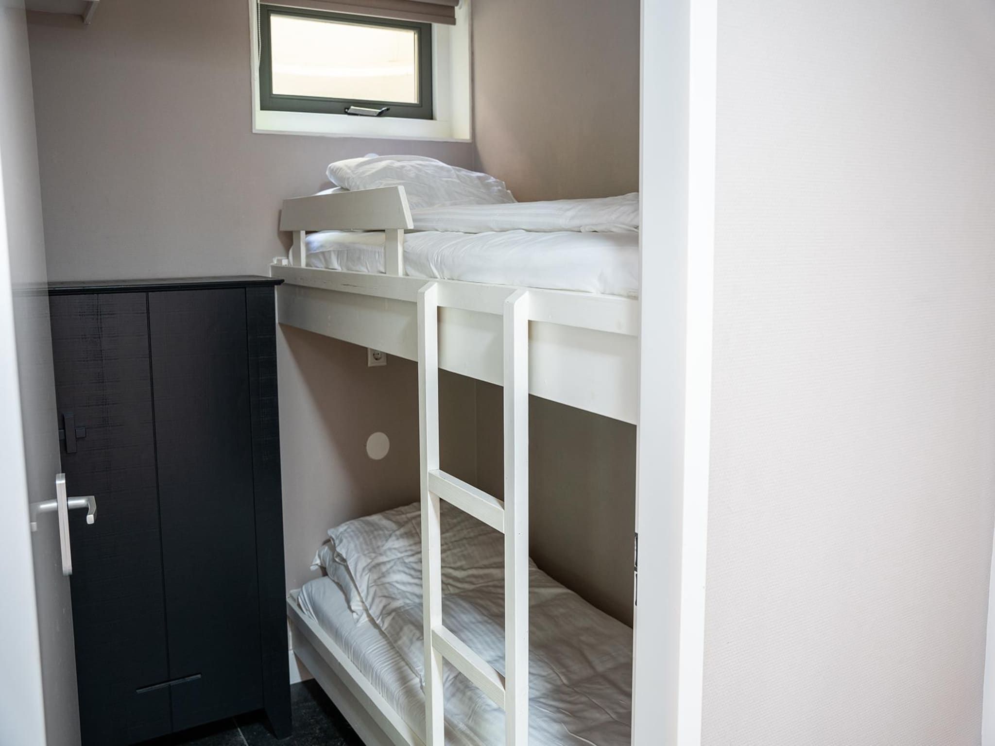 Een slaapkamer van Vlindervallei Boshuis 16p in Ermelo