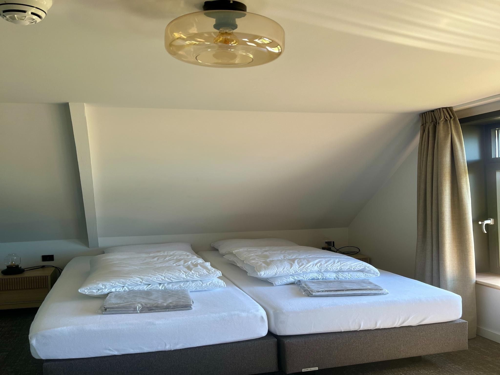 Een slaapkamer van Groepsaccommodatie voor 20 personen + 5 Tiny Greenhouses voor 2 tot 4 personen in Scherpenzeel (FR)