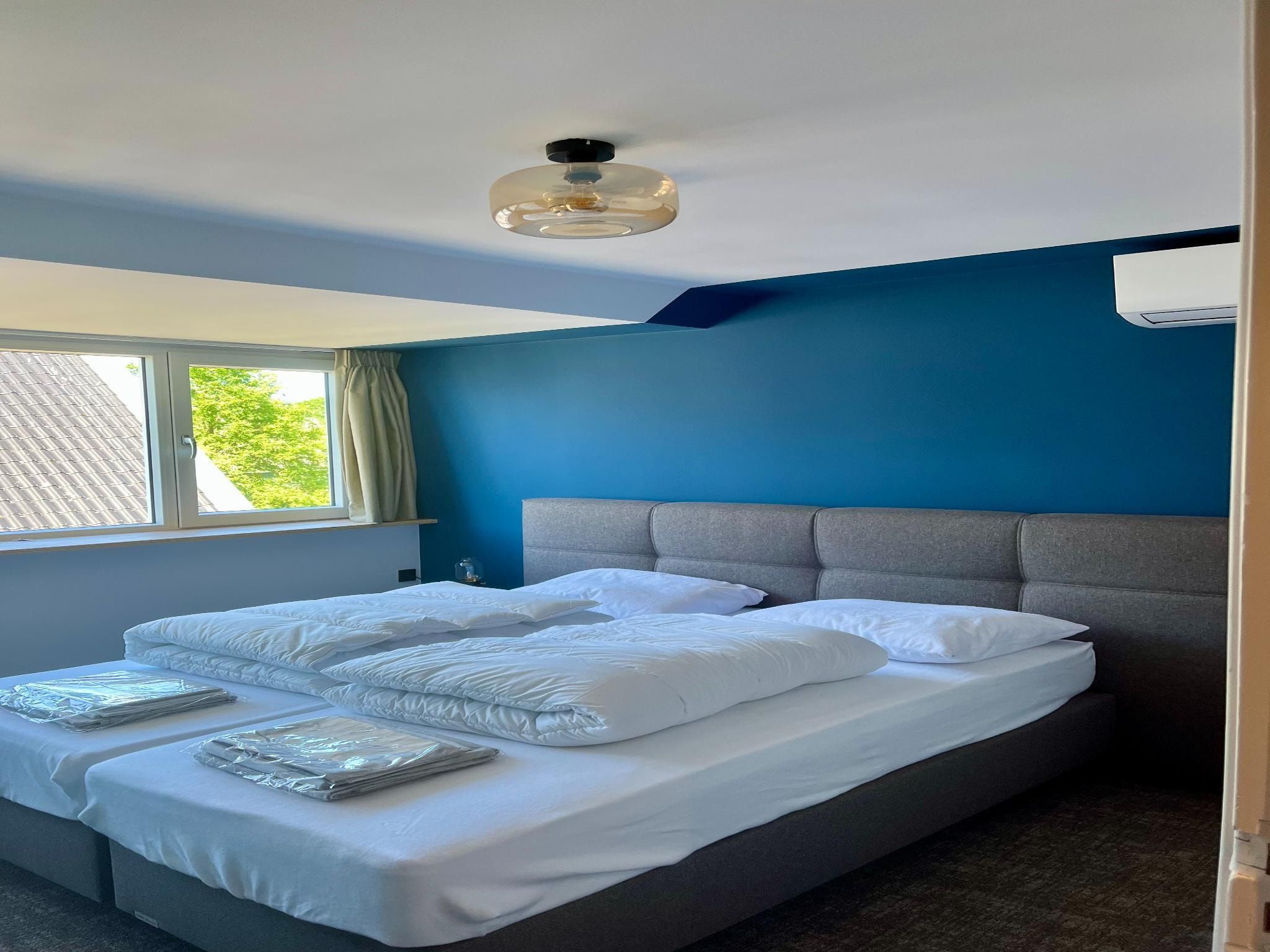 Een slaapkamer van Groepsaccommodatie voor 20 personen + 5 Tiny Greenhouses voor 2 tot 4 personen in Scherpenzeel (FR)