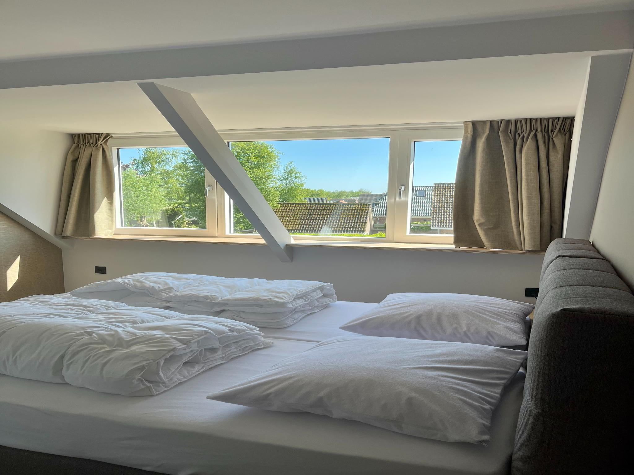 Een slaapkamer van Groepsaccommodatie met 10 luxe tweepersoons kamers in Scherpenzeel (FR)