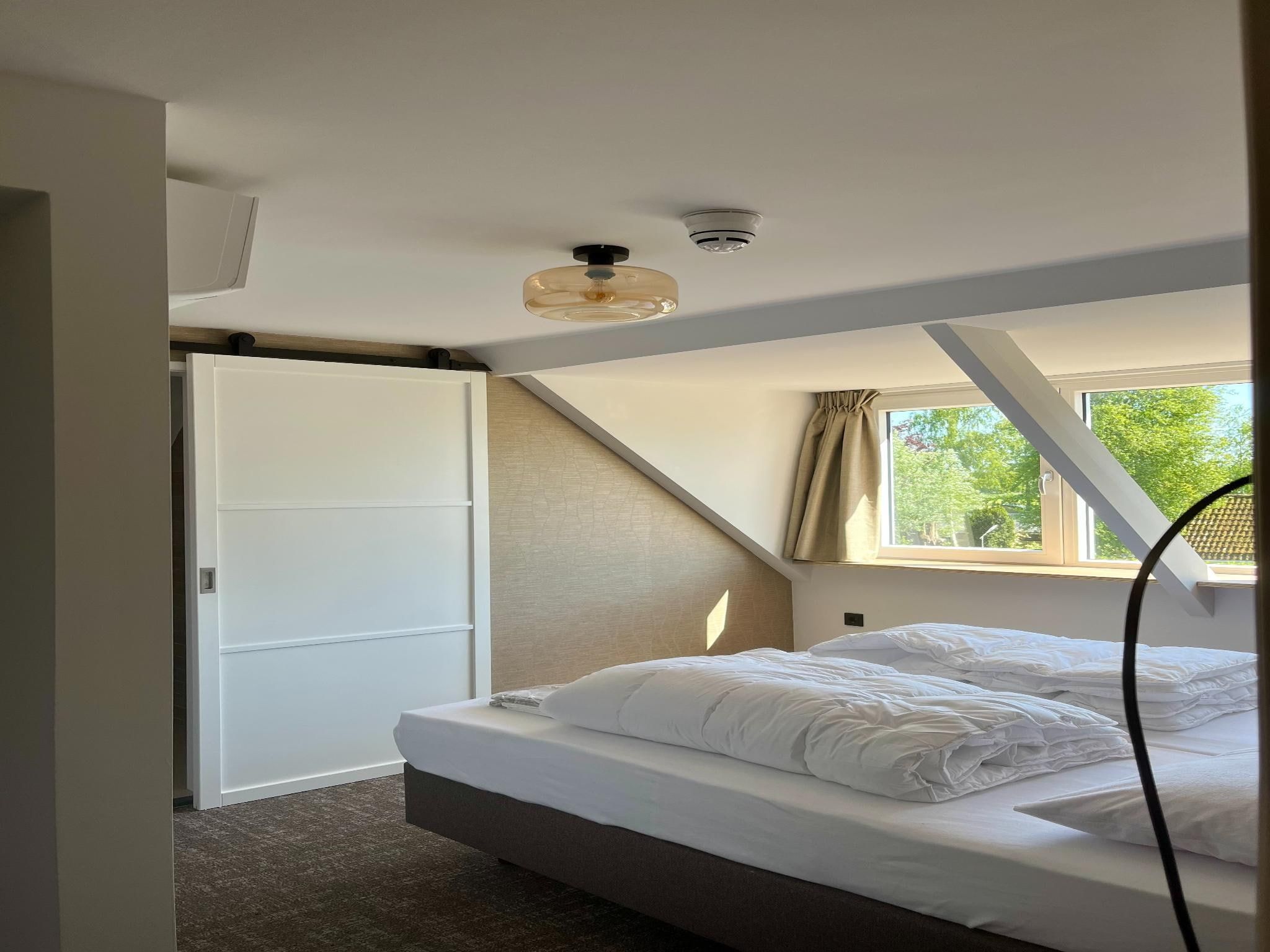 Een slaapkamer van Groepsaccommodatie met 10 luxe tweepersoons kamers in Scherpenzeel (FR)